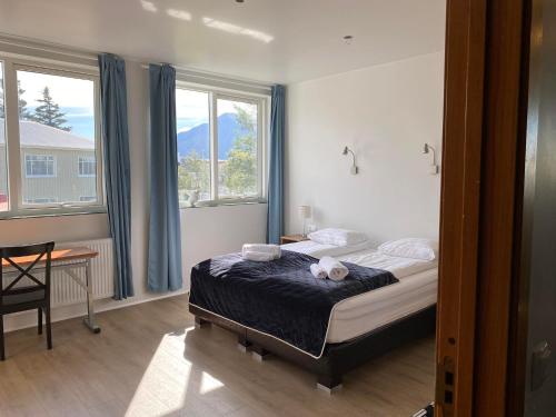 a bedroom with a bed with a teddy bear on it at City Hall Apartments in Borgarnes