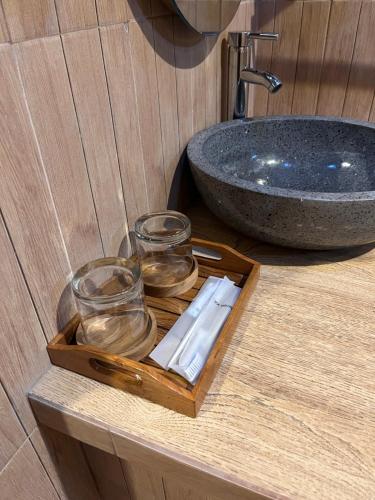 a wooden tray with two glasses and a sink at Villa Lumbung Sidemen in Sidemen