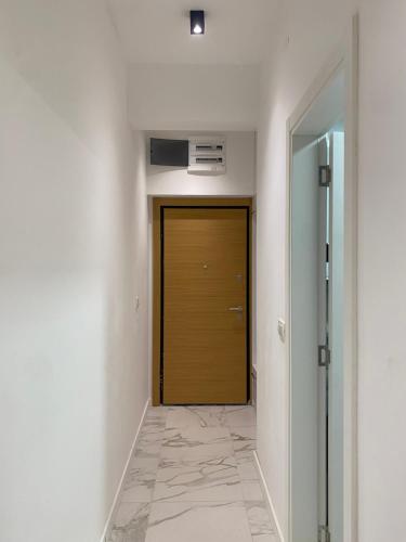 a hallway with a wooden door in a room at BIJELA apartman 2025 in Bijela