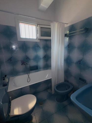 a bathroom with a toilet and a sink and a tub at Village Memories in Koronópoulon