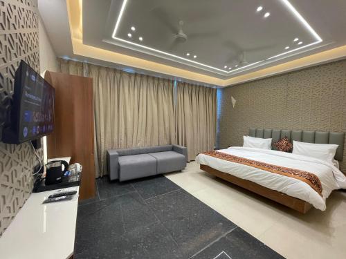 a bedroom with a bed and a flat screen tv at Hotel Vishwaraj Residency in Solapur