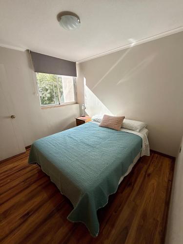 a bedroom with a bed and a window at Departamento Amplio y tranquilo in Talca