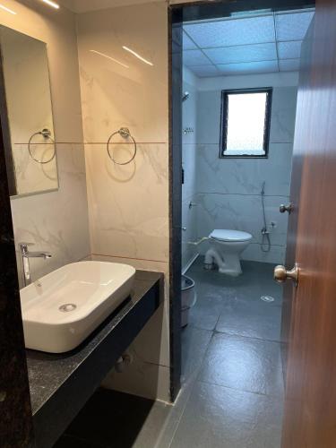 a bathroom with a sink and a toilet at Hotel Vishwaraj Residency in Solapur