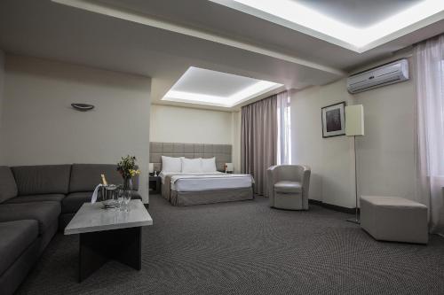 a hotel room with a couch and a bed at Aviatrans Hotel in Yerevan
