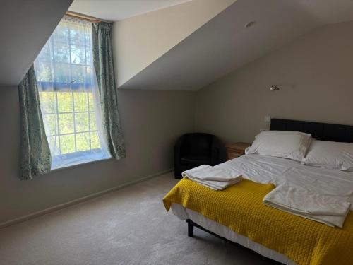 a bedroom with a bed and a window at Meadows Hotel in Perranzabuloe