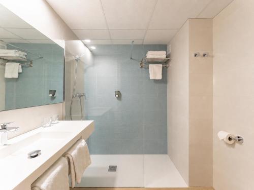 a bathroom with a shower and a sink and a mirror at Hotel La Rápita in Sant Carles de la Ràpita
