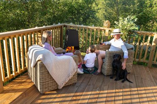 a group of people sitting in wicker chairs on a deck at Hazel Tree Yurt - Eavestone Lake in Grantley