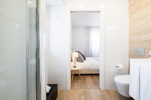 a bathroom with a toilet and a bed in a room at Alojamento Local Vitoria in Batalha