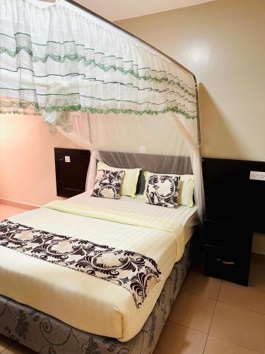 a bedroom with a bed with a canopy at Ebenezer resort hotel in Mbale