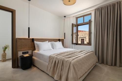a bedroom with a large bed and a window at Karavel Suites - Old Town Boutique Rooms in Rhodes Town