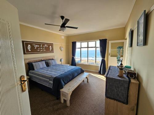 a bedroom with a blue bed and a window at On The Beach Scottburgh in Scottburgh