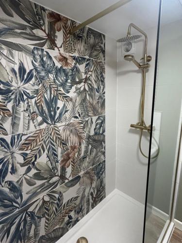 a shower in a bathroom with a black and white wallpaper at Owl Cottage - sleeps 5 near Brecon Beacons, Zip World, Bike Park Wales in Llwydcoed Station