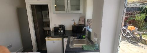 a kitchen with a sink and a bike in a room at lovely Studio Flat in The Hyde