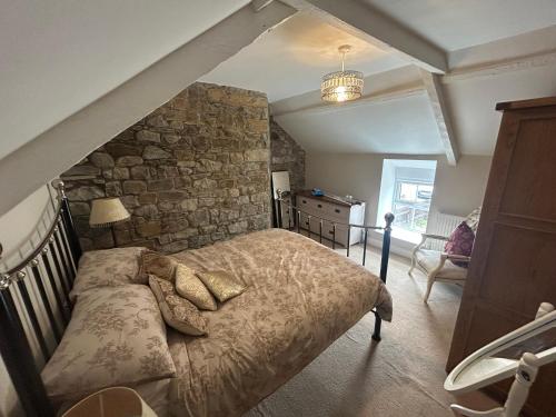 a bedroom with a bed and a stone wall at Owl Cottage - sleeps 5 near Brecon Beacons, Zip World, Bike Park Wales in Llwydcoed Station