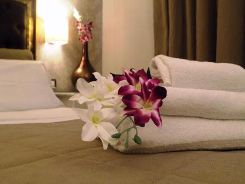 a bouquet of flowers sitting next to towels on a bed at Hotel Residence Villa Del Mare in Rimini