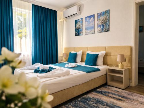 a hotel room with a bed with blue curtains at Guest House Kolev - central in Nesebar