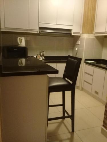 a black chair sitting at a counter in a kitchen at Homestay KBCC in Kota Bharu