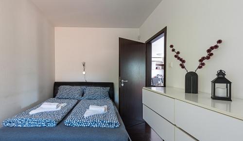 a bedroom with a bed with a dresser and a mirror at Six Corners Mystic Corner City View Balcony Apartment in Pécs