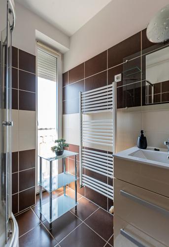 a bathroom with a sink and a shower at Six Corners Mystic Corner City View Balcony Apartment in Pécs