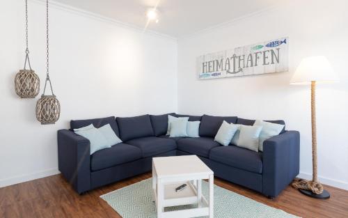 a living room with a blue couch and a table at Düne, App 7 in Duhnen