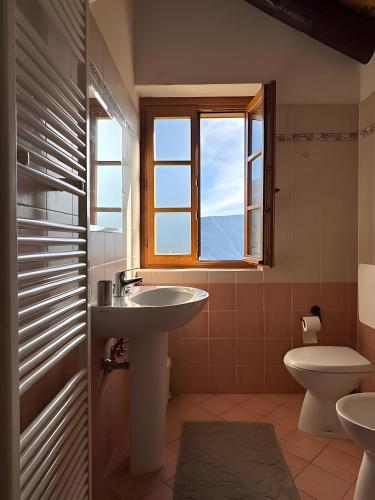 a bathroom with a sink and a toilet and a window at Mountain hut 'la Fraccia' in Trasquera