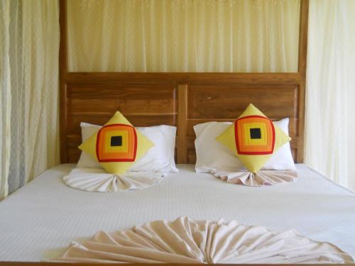Una cama con dos almohadas encima. en Sunset Tourist Home en Polonnaruwa
