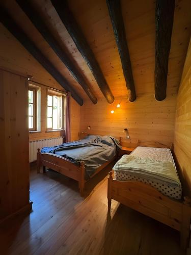 a bedroom with two beds in a log cabin at Mountain hut 'la Fraccia' in Trasquera