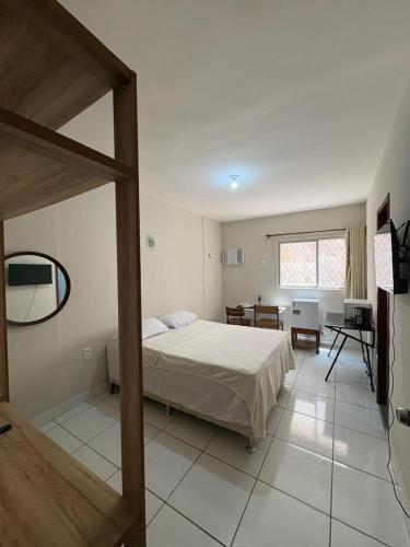 a bedroom with a bed and a desk in it at Residencial Sol - Cidade alta in Natal