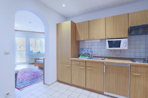 a kitchen with wooden cabinets and a sink and a microwave at Düne, App 12 in Duhnen