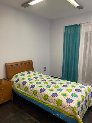 a bedroom with a bed with a flower blanket on it at Cozy beach apartment in Saronida in Saronida
