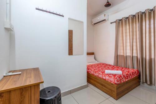 a small room with a bed and a desk at Oreo rooms in Kozhikode