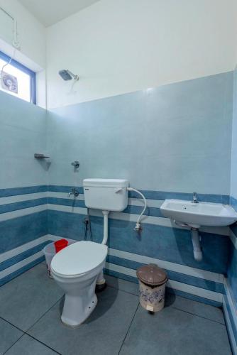 a bathroom with a toilet and a sink at Oreo rooms in Kozhikode