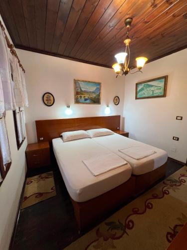 a bedroom with a large bed with a wooden ceiling at Hava Baci (old town) in Berat