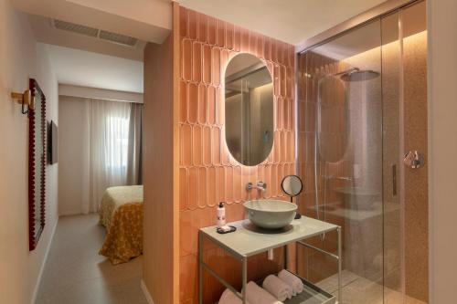 a bathroom with a sink and a shower with a mirror at Inturotel Esmeralda Villas in Cala d´Or
