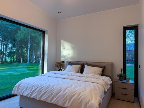 a bedroom with a bed and a large window at Jõelähtme Golf Villa with Sauna and Terrace Grill - near EGCC Golf Course in Manniva