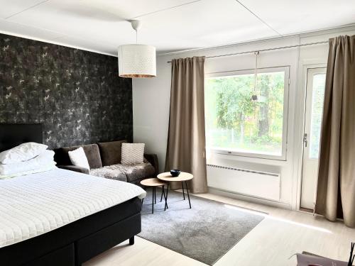 a bedroom with a bed and a couch and a window at Helmi Villa, keskellä Vuokatti Sauna Ilmainen Pysäköinti Wi-Fi in Vuokatti