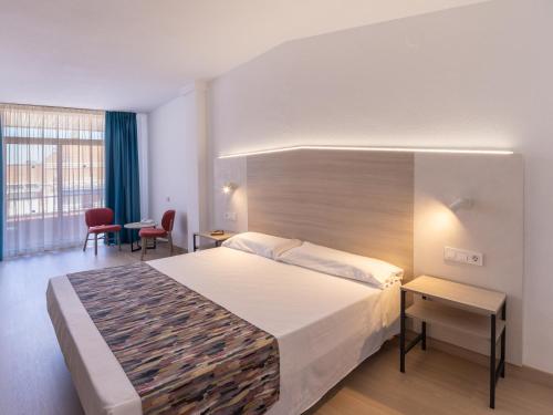 a hotel room with a bed and a table and chairs at Hotel La Rápita in Sant Carles de la Ràpita
