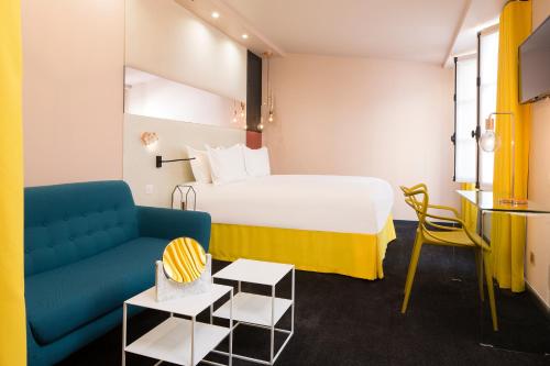 a hotel room with a bed and a couch at Hotel Duette Paris in Paris