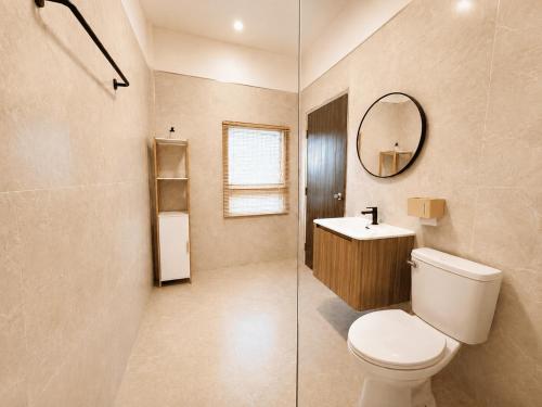 a bathroom with a toilet and a sink and a mirror at Beyond Stay Thong Lor 11 in Bangkok