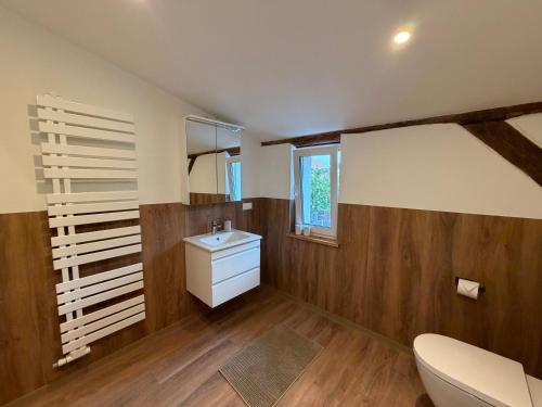 a bathroom with a white sink and wooden walls at Doppelapartment alte Bäckerei in Feldberg