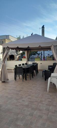 a table and chairs under a large umbrella at Casa Relax vicino a Otranto in Giurdignano