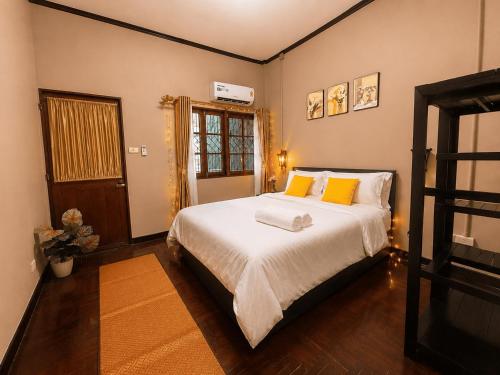 a bedroom with a large bed with yellow pillows at Beyond Stay Thong Lor 11 in Bangkok