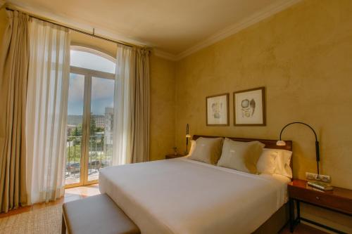 a bedroom with a large bed and a large window at Hotel Bremon by Grup Duquessa in Cardona