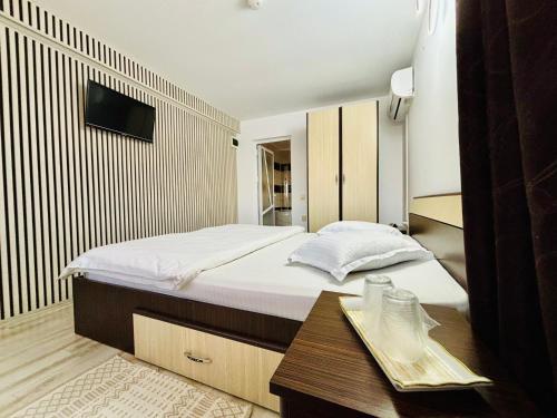 a bedroom with a large bed and a table at Casa Maruska in Murighiol