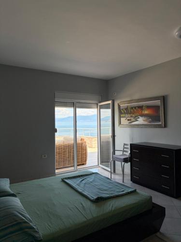 a bedroom with a bed and a view of the ocean at Pogradec Lakeview Apartament in Pogradec
