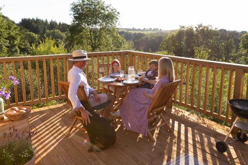 a group of people sitting at a table on a deck at Hazel Tree Yurt - Eavestone Lake in Grantley