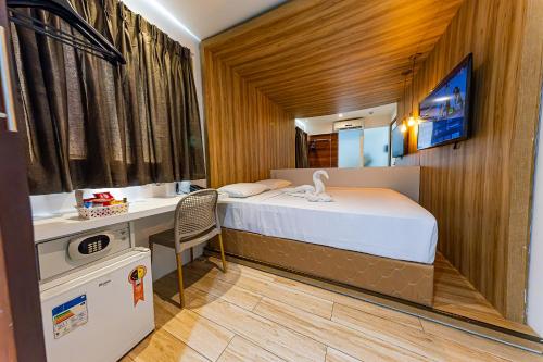 a small bedroom with a bed and a desk at Ecco Hotel Fortaleza in Fortaleza