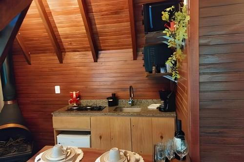 a small kitchen with a sink and a counter at Cabana Andorinha in Três Coroas