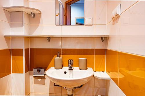 a bathroom with a sink and a mirror at Sapphire Hotel Rooms Lechicka in Poznań