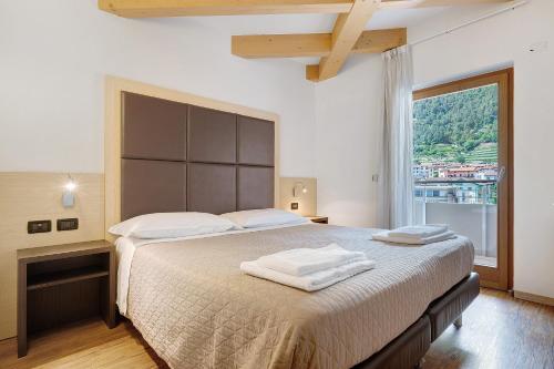 a bedroom with a large bed with a large window at Cameras Mori in Mori